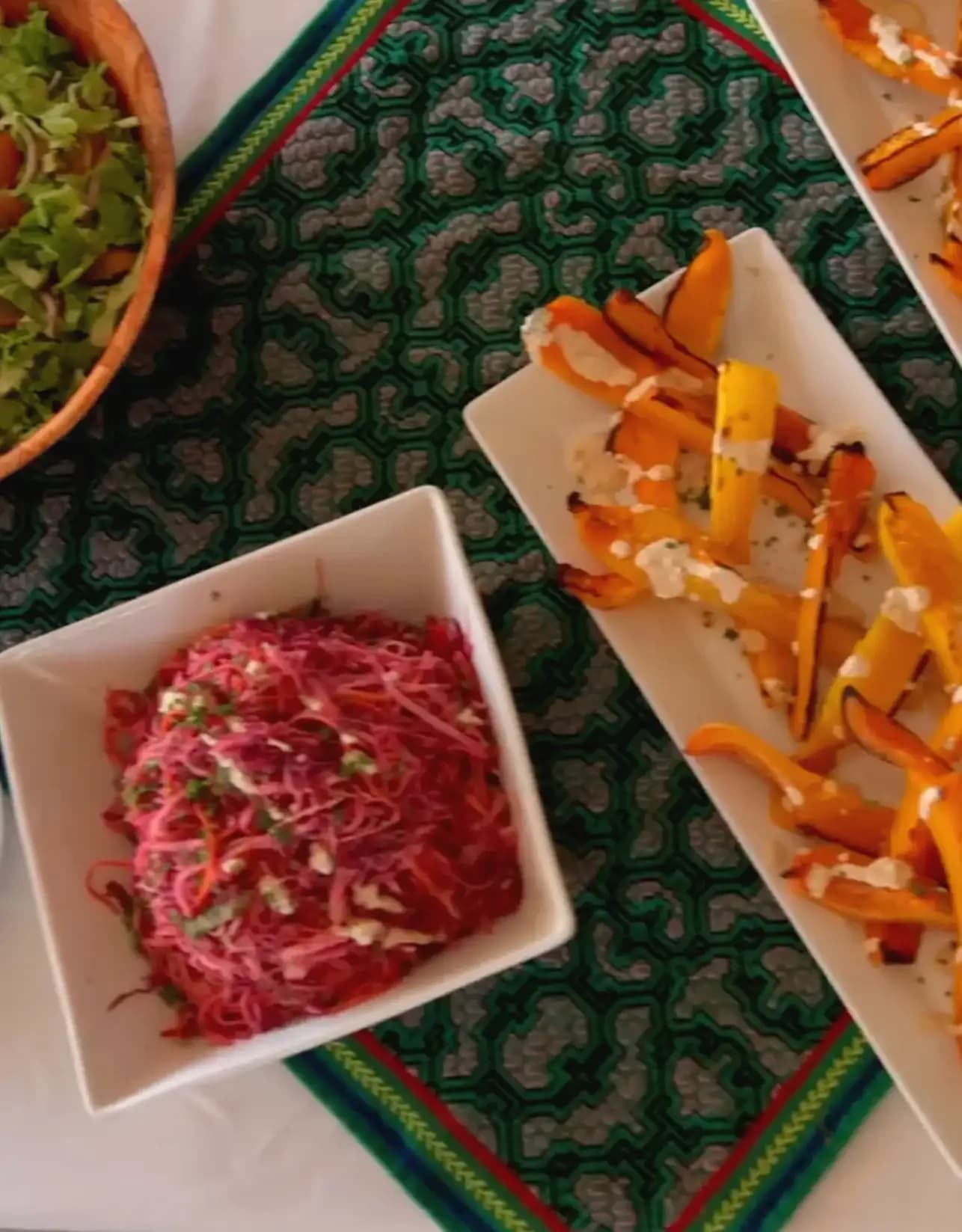 Prepared meal and vegetables arranged on a patterned tablecloth